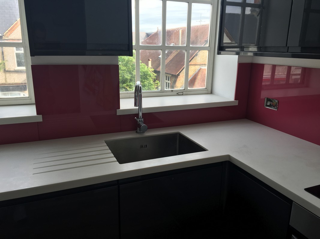Deep plum coloured glass splashback in modern Finsbury Park kitchen